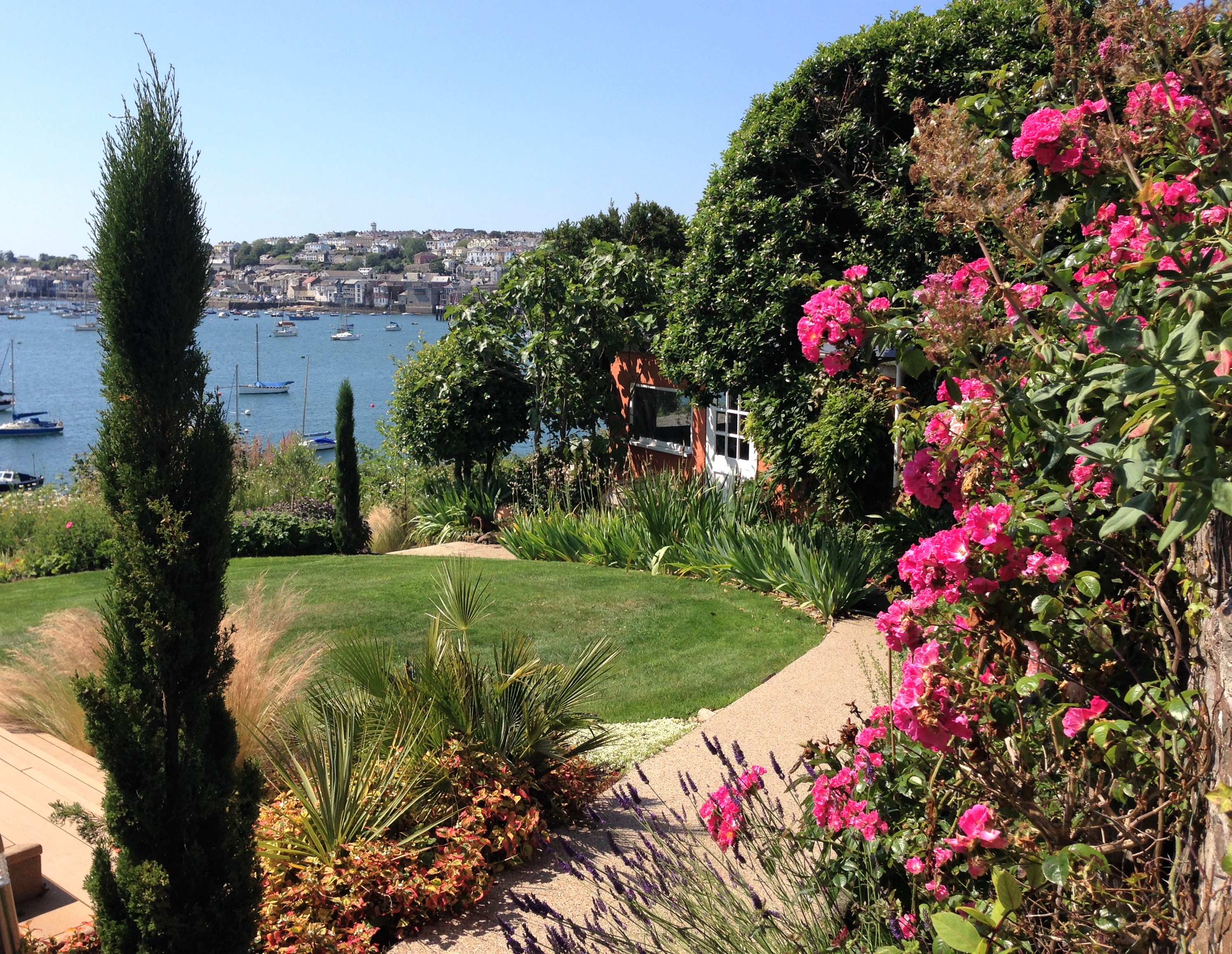 View of Falmouth harbour through a garden in Flushing Cornwall